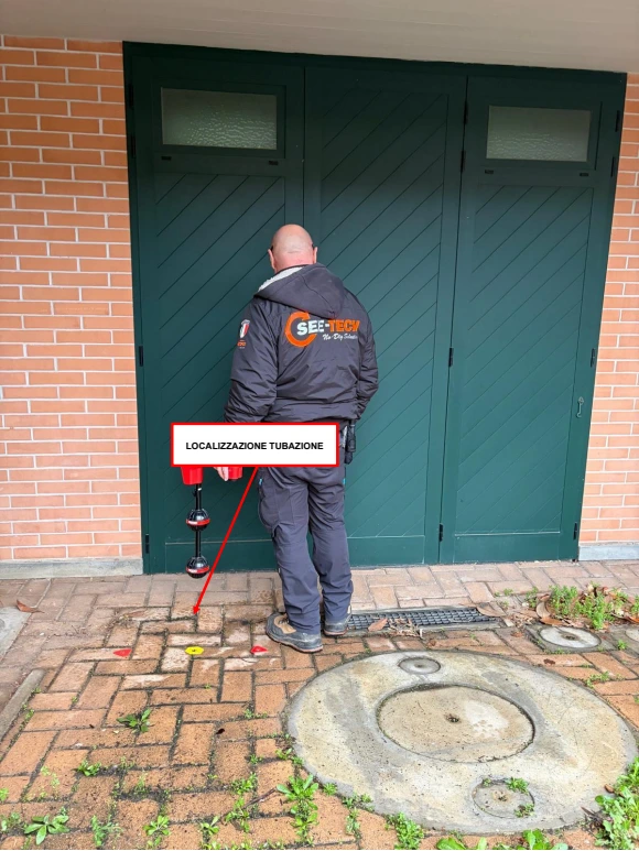 Localizzazione della tubazione sulla pavimentazione davanti al garage con freccia originale